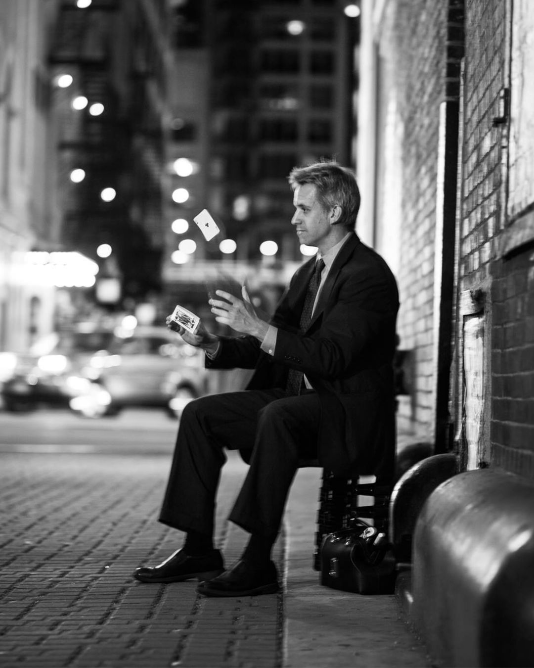 James Sanden in an alley playing with a deck of cards.