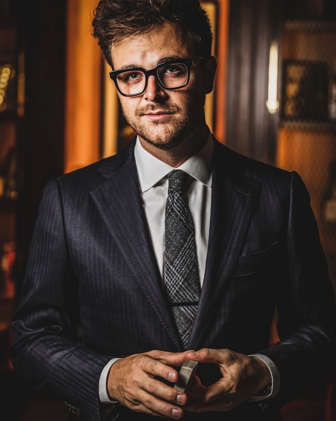 Headshot of Ryan Plunkett holding a deck of cards. 