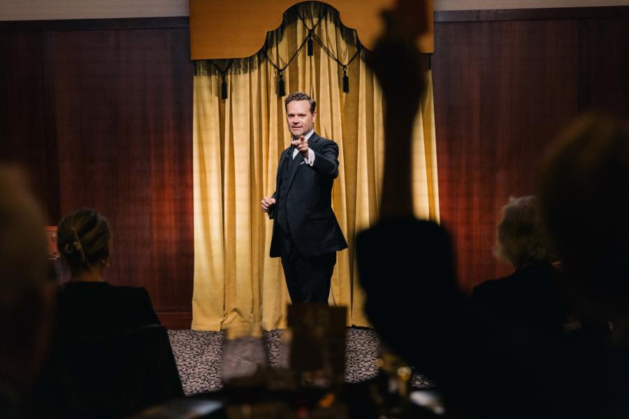 Dennis pointing at the audience from stage. 