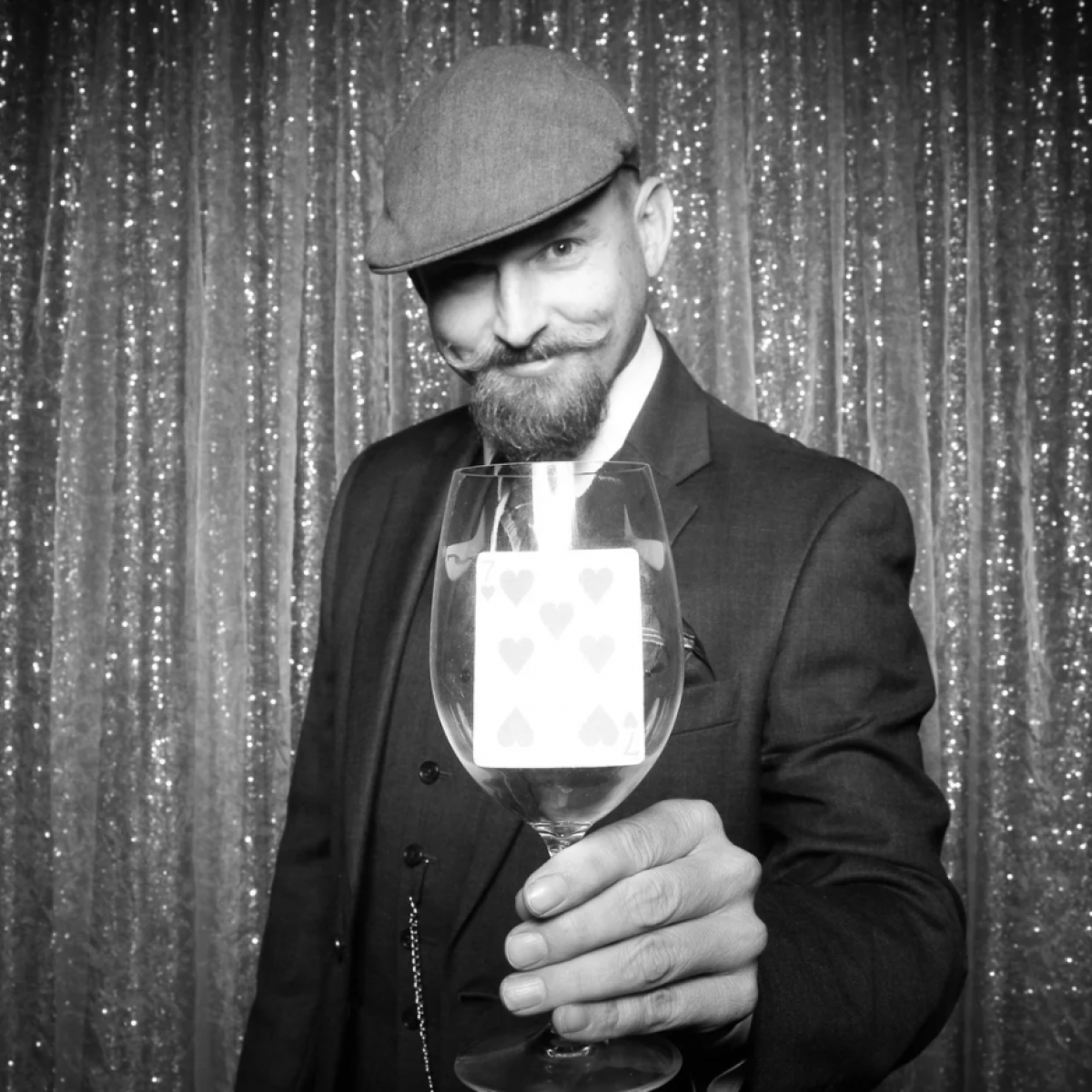 Photo of Mike holding wine glass with playing card in the glass.
